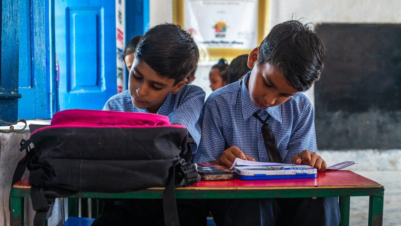 Pupils at a desk working through a book