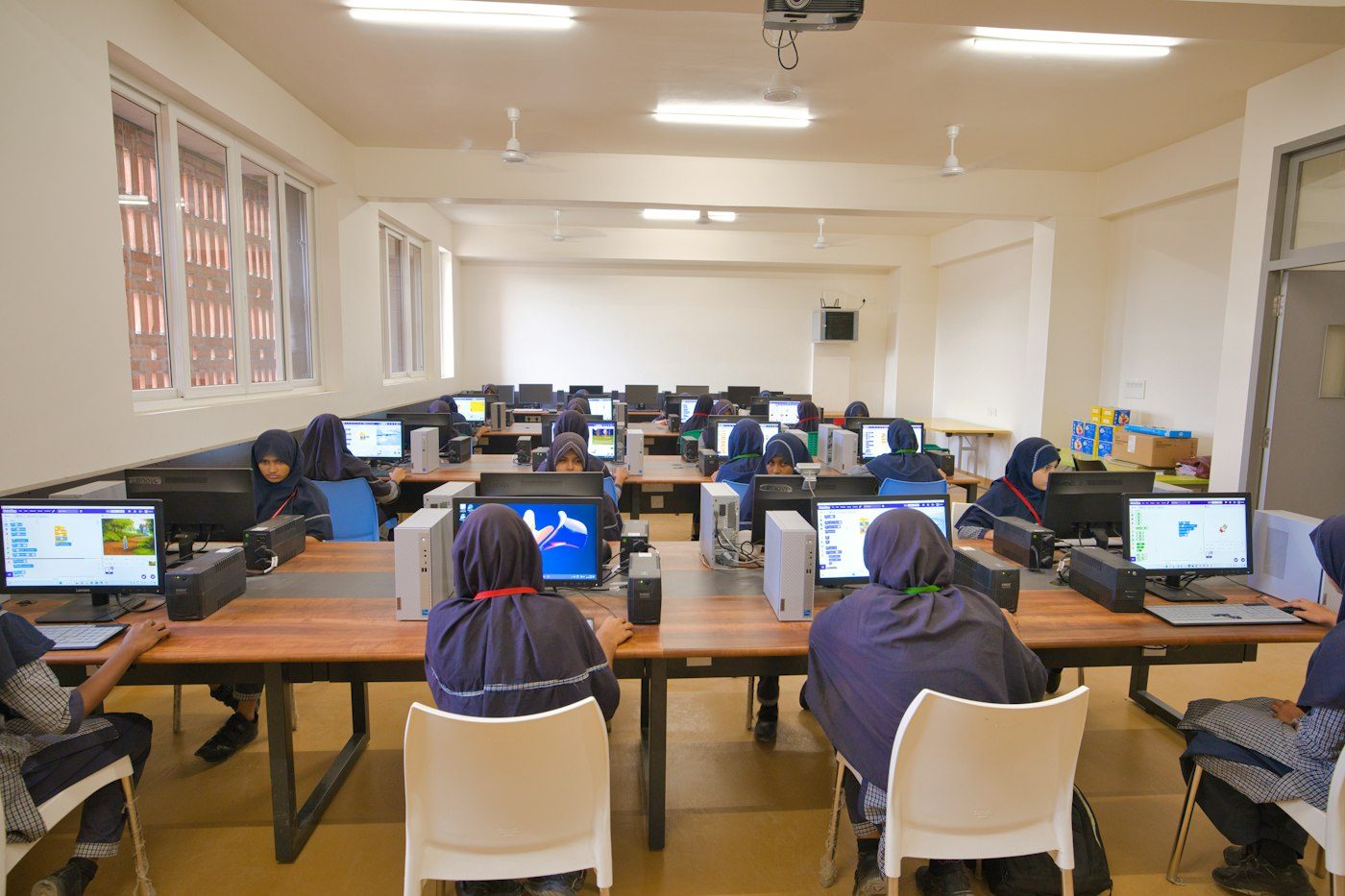 A school computer lab, pupils working at desktop machines
