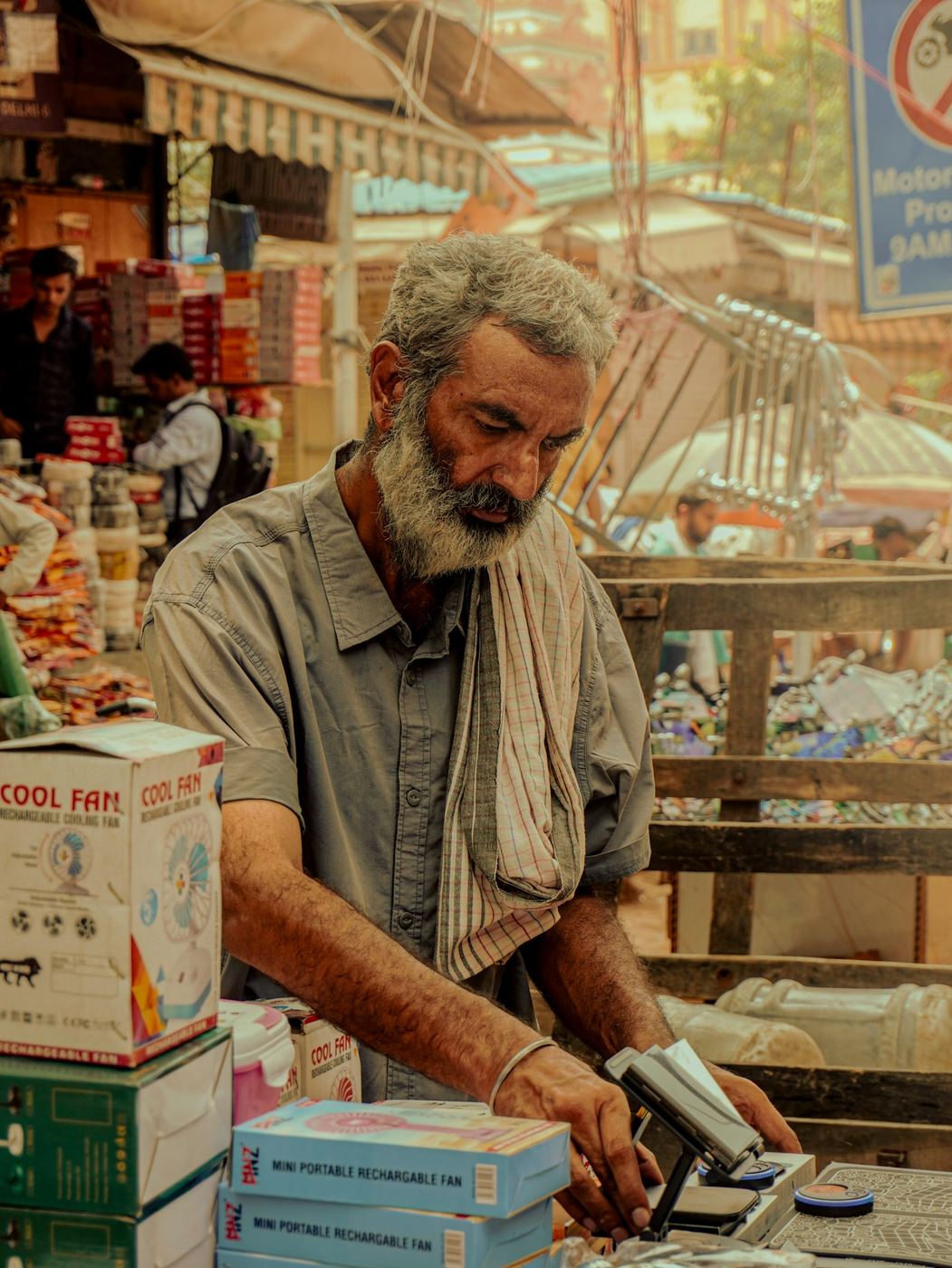A market trader at his stall, serving a regular customer