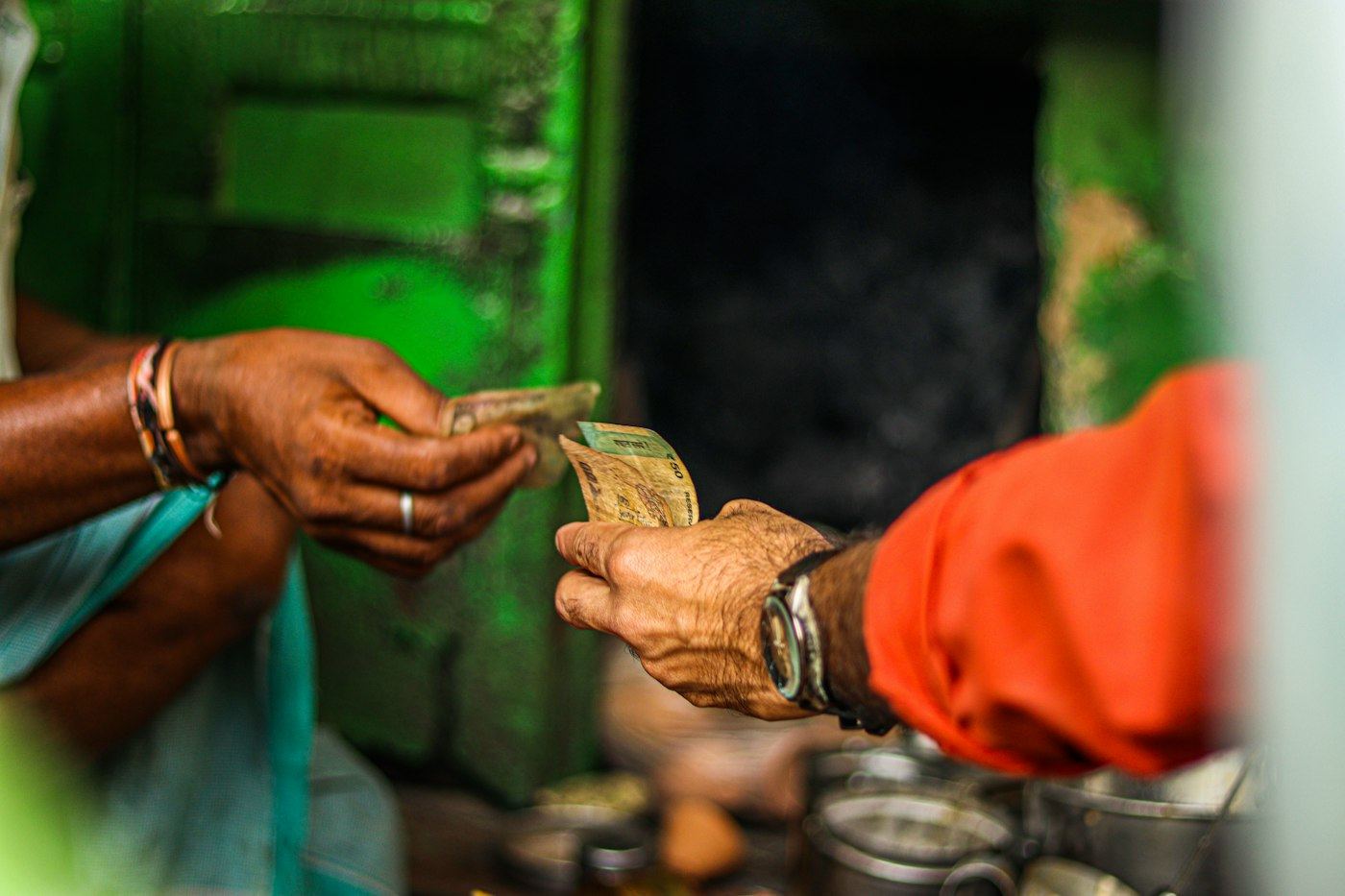 A banknote passing between customer and shopkeeper