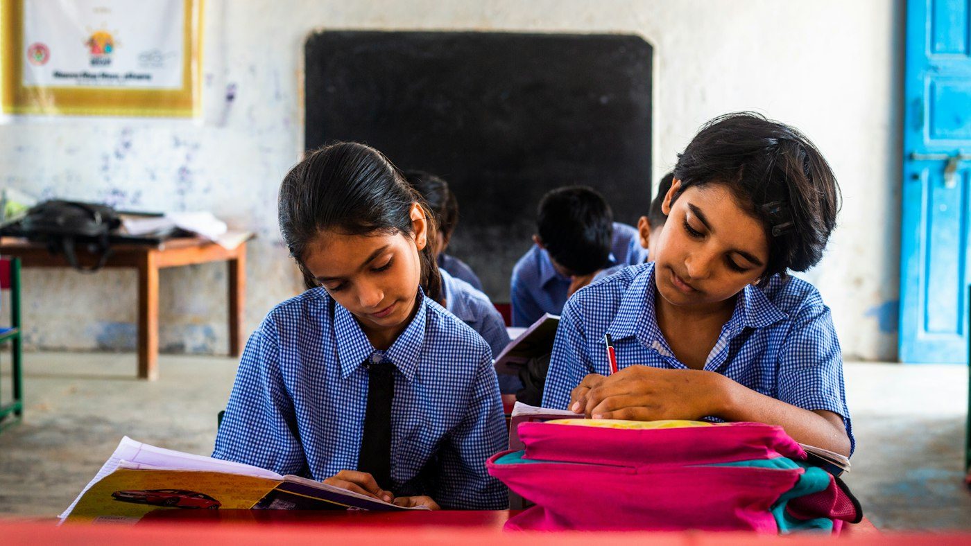 Two pupils sharing a desk in an Indian classroom